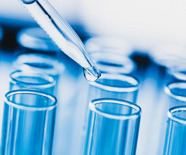 Lab. A close-up of a laboratory glass pipette with emerging drop lab audit water