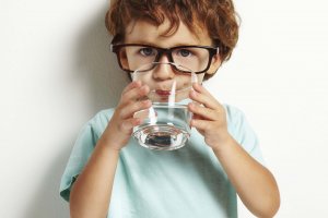 Portrait,Of,Boy,Drinking,Glass,Of,Water,Isolated,In,White